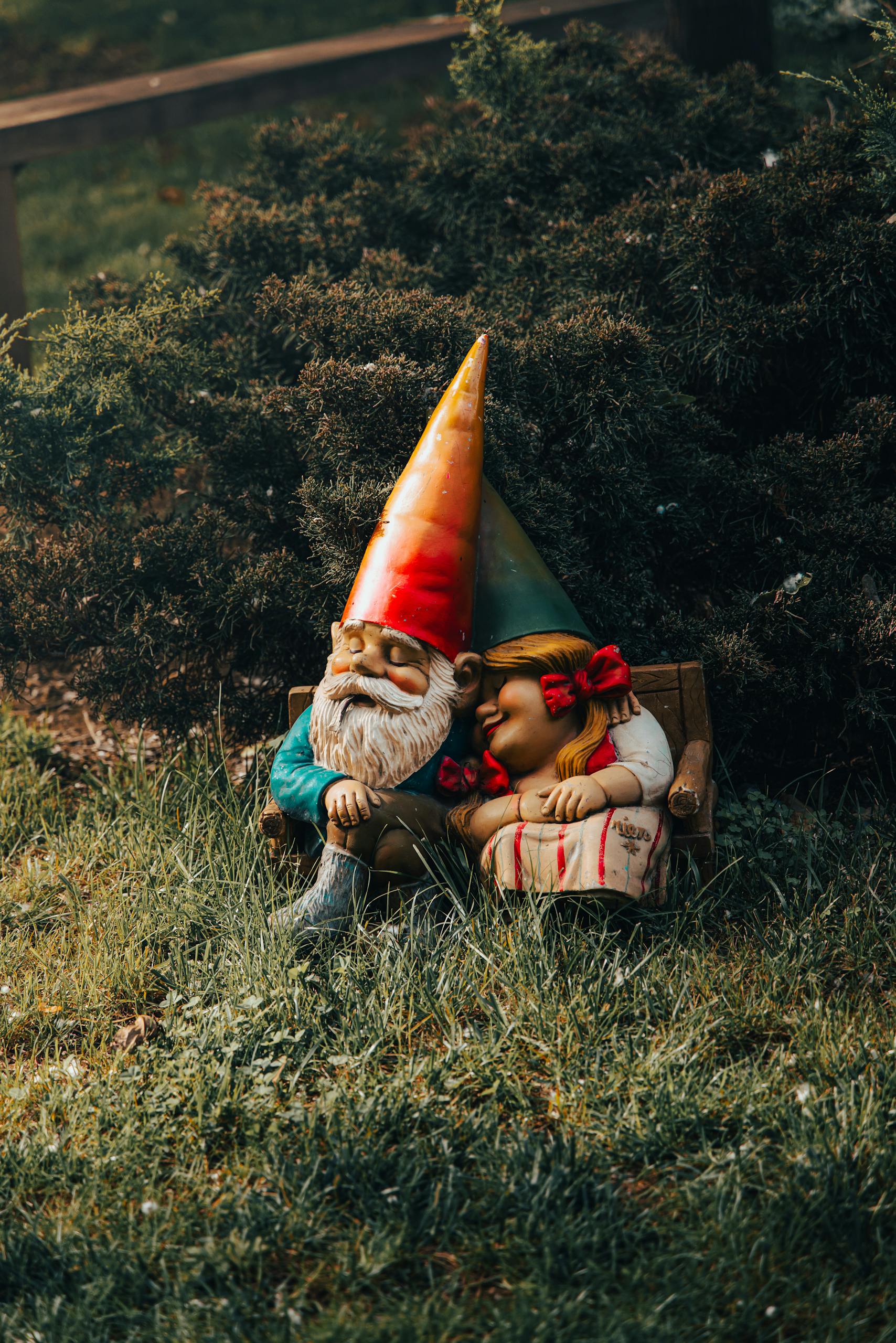 Colorful garden gnomes cozily resting on a bench amidst lush greenery, evoking tranquility.
